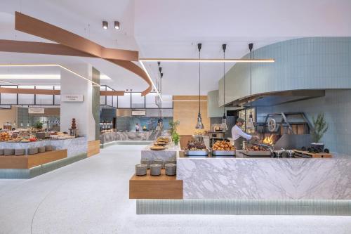 a kitchen with a chef preparing food in a restaurant at Fairmont The Palm Residences I Access to Hotel Facilities in Dubai