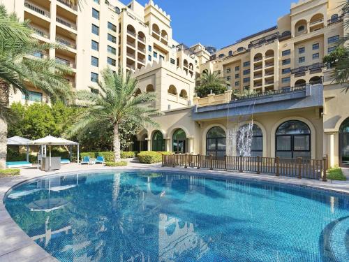 a large swimming pool in front of a building at Fairmont The Palm Residences I Access to Hotel Facilities in Dubai