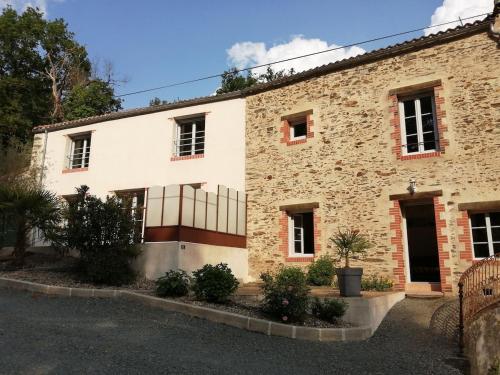 a large stone building with a fence in front of it at Gîte La Rocardière XL 10 personnes in Mouchamps