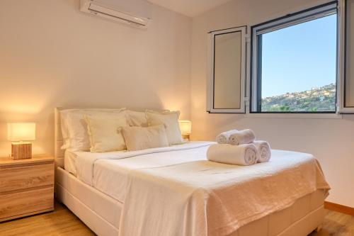 a bedroom with a large white bed with towels on it at Casa Familia Pestana 2, a Home in Madeira in Seixal