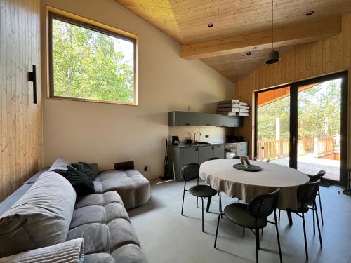 a living room with a couch and a table at GRANIASTY - nowoczesny dom wakacyjny z basenem in Smażyno
