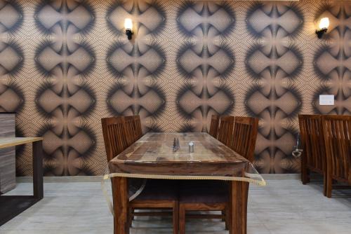 a table and chairs in a room with a wallpaper at Indra Palace in Jaipur