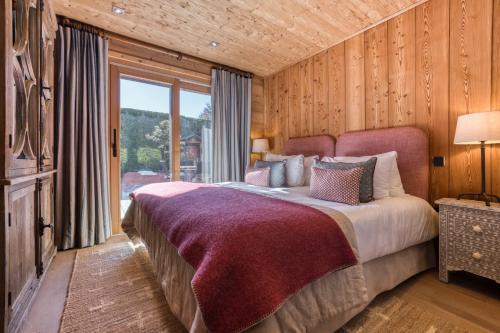 a bedroom with a large bed and a large window at Apartment Au Bon Coin - Luxury Chamonix Hidden Haven, Mont Blanc view, Hot Tub and Garden in Chamonix-Mont-Blanc