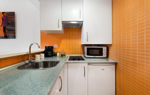 a kitchen with a sink and a microwave at RETIRO-IBIZA ALQUILER TEMPORAL-Hospitales in Madrid