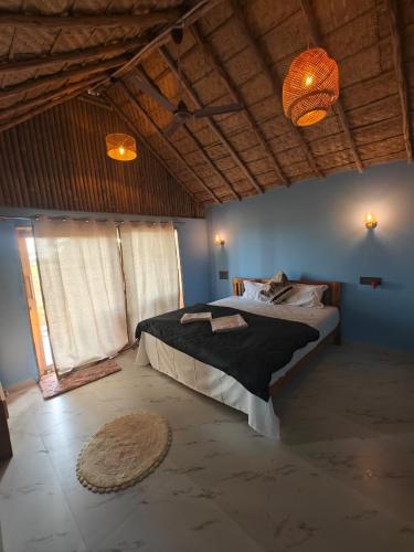 a bedroom with a large bed in a room at The Sundown Hampi in New Hampi
