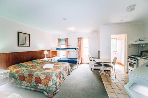 una habitación de hotel con una cama y un escritorio en Augusta's Georgiana Molloy Motel, en Augusta
