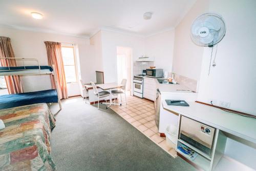 a bedroom with a bunk bed and a kitchen at Augusta's Georgiana Molloy Motel in Augusta