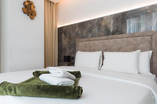 a bedroom with a bed with towels on it at Sky Suites-KASS Towers in Okponglo