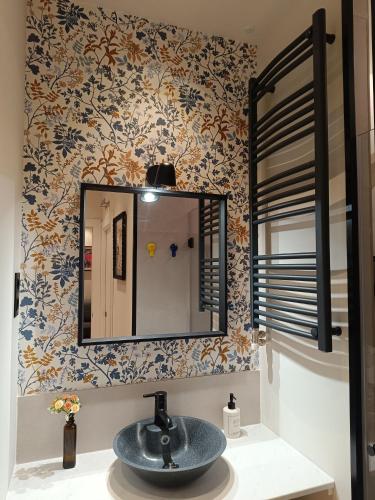 ein Badezimmer mit Waschbecken und Spiegel in der Unterkunft Piso Carpio, 22 by pisoschulospuntoes in León