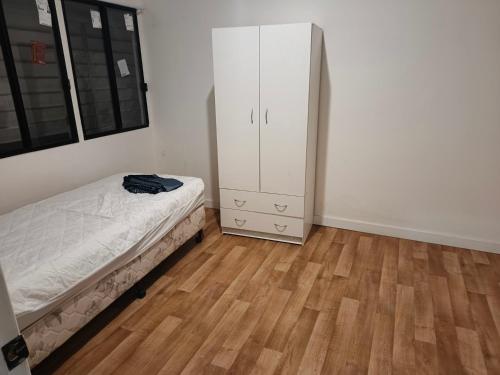 a bedroom with a bed and a white cabinet at Room in Hostel in Rockhampton