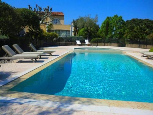 einen Pool mit blauem Wasser und Liegestühlen in der Unterkunft Villa Laguna Haven in Saint-Tropez