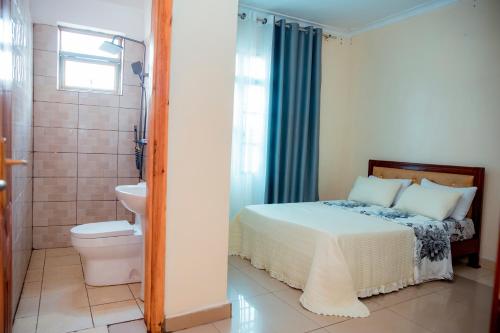 a bedroom with a bed and a toilet and a shower at THELIGHT SUITES KIGALI Rwanda in Kigali