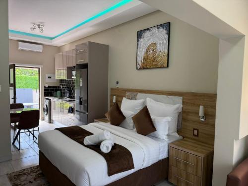 a bedroom with a large bed and a kitchen at Fezeu's Place in Johannesburg