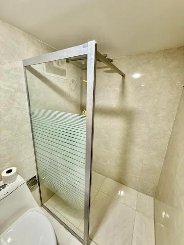 a glass shower in a bathroom with a toilet at Glow of Wadi Rum Camp in Wadi Rum
