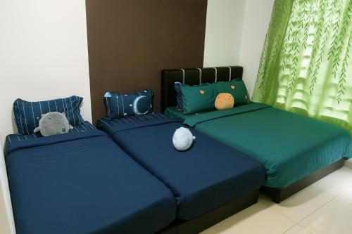 two beds in a room with stuffed animals on them at Cozy homestay Manhattan Ipoh,12 pax 怡保民宿 in Ipoh