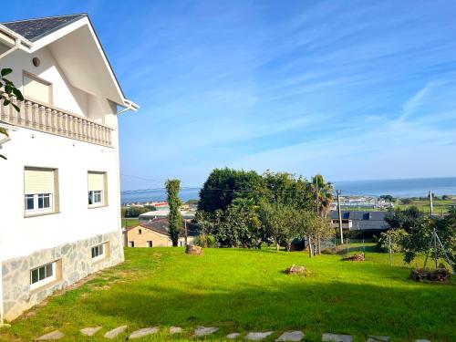 a grassy yard next to a white building at Casa Naveira vistas mar en Foz in Foz