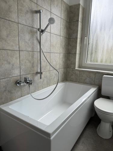 a white bath tub in a bathroom with a toilet at Monteur Budget-Ferienhaus in Hof, stadtnähe in Hof