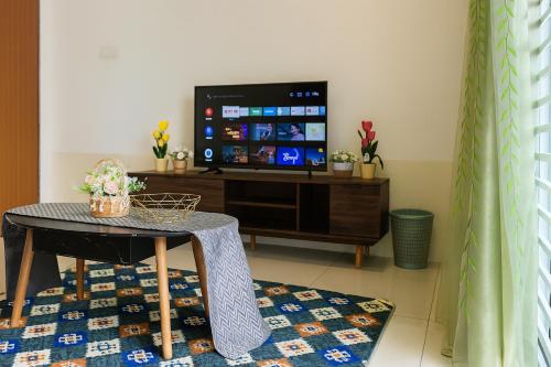a living room with a table and a tv at Cozy homestay Manhattan Ipoh,12 pax 怡保民宿 in Ipoh
