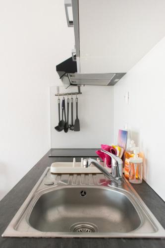a kitchen counter with a sink and utensils at Au Fil Des Vagues in Palavas-les-Flots