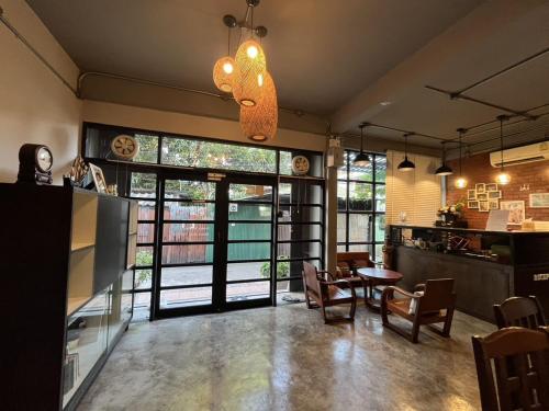 Una habitación con una mesa y sillas y una ventana grande. en BNK89 Hostel, en Bangkok