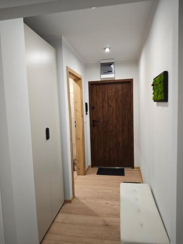 a hallway with a wooden door and a wooden floor at Karkonoskim Szlakiem in Kamienna Góra