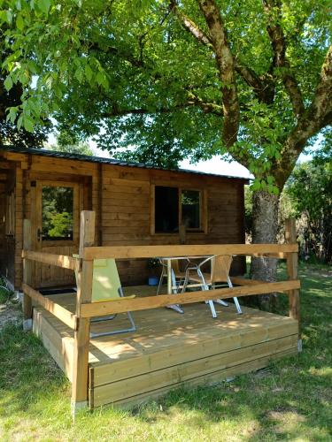 a log cabin with a table and chairs on a deck at Astral in Prunay-Cassereau