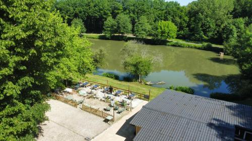 an overhead view of a lake with people sitting at tables at Astral in Prunay-Cassereau