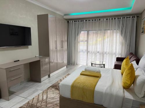 a bedroom with a large bed and a television at Fezeu's Place in Johannesburg