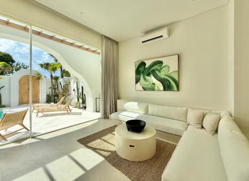a living room with a white couch and a table at Dolce Suites in Bingin Beach