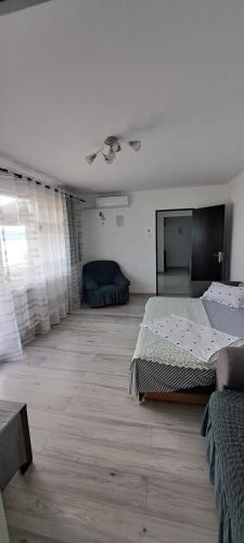 a bedroom with two beds and a large window at Apartament Edy in Orşova
