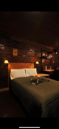 a bedroom with a bed with a table on it at Pousada GPC in Macaé