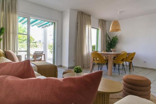 a living room with a table and chairs at Pura Vida by Maspalomas Holiday Villas in Pasito Blanco