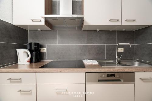 a kitchen with white cabinets and a sink at Wiesenweg W07 in Laboe