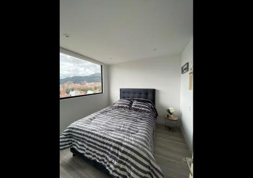 a bedroom with a bed with a large window at Infinity Rooftop Pool Penthouse with 24h Gym, Near Zona T! in Bogotá
