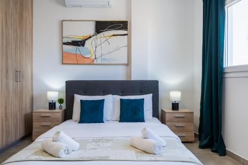 a bedroom with a bed with two towels on it at Hilltop 2-Bedroom Apartment in Larnaca