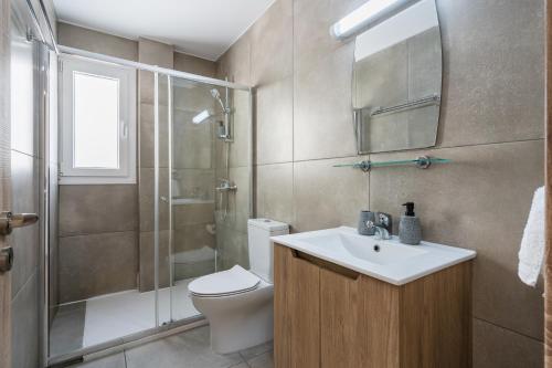 a bathroom with a toilet and a sink and a shower at Hilltop 2-Bedroom Apartment in Larnaca