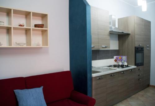 a living room with a red couch in a kitchen at The Liberty Palace in Campobello di Licata