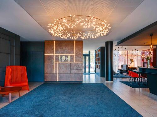 a lobby with a chandelier and a dining room at Hôtel Mercure Toulon La Seyne-Sur-Mer in La Seyne-sur-Mer