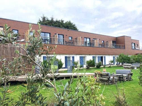 ein Mehrfamilienhaus mit Terrasse und Garten in der Unterkunft Hôtel Des Argousiers in Ambleteuse