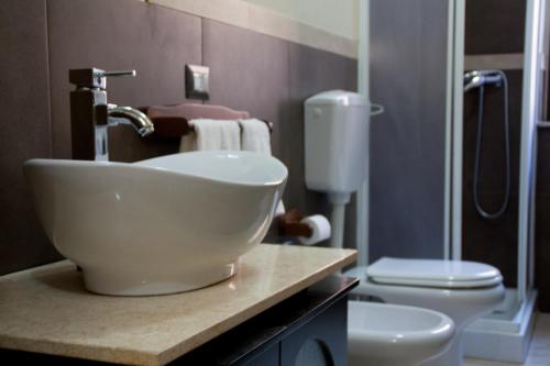 a bathroom with a bowl sink and a toilet at The Liberty Palace in Campobello di Licata