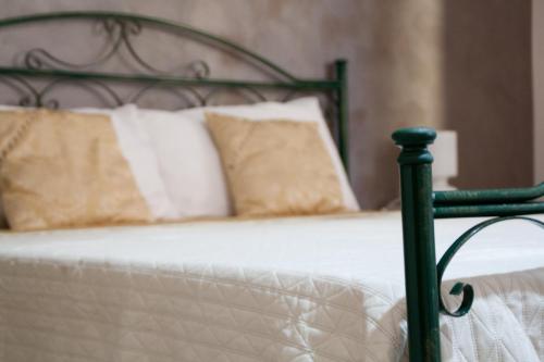 a green bed with white sheets and pillows at The Liberty Palace in Campobello di Licata