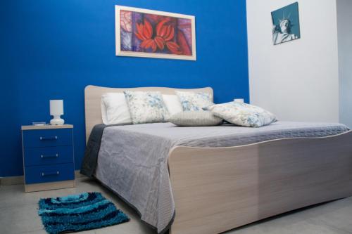a bedroom with a bed with a blue wall at The Liberty Palace in Campobello di Licata