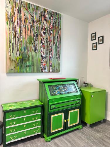 a room with two green dressers and a painting at Бутик хотел ресторант брасери и релакс зона Сажитариус in Kyustendil