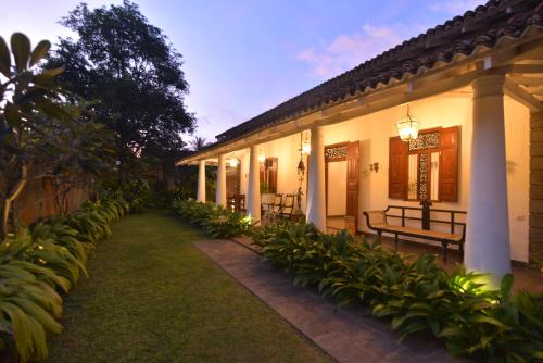 une cour d'une maison avec des bancs et des plantes dans l'établissement Dhyana Beach Villa, à Ambalangoda