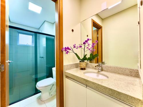 a bathroom with a sink and a toilet at Apto Frente Mar Bali Beach Home Club 3 Quartos Climatizados Cozinha Completa Sacada com Churrasqueira 2 Vagas de Garagem Piscina borda infinita Sauna Academia Cinema Quadra Salão de Jogos Pé na Areia 15min do Beto Carrero in Piçarras
