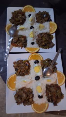 Tres platos blancos con comida y rodajas de naranja. en Desert Camel Trek, en Merzouga