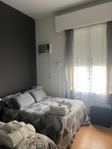 a bedroom with a bed and a window with towels on it at Corazón obelisco 3 in Buenos Aires