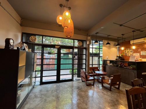 a dining room with a table and chairs and a window at BNK89 Hostel in Bangkok