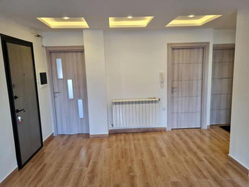 an empty room with wooden floors and two doors at Cozy, 15 min from town centre in Sétif