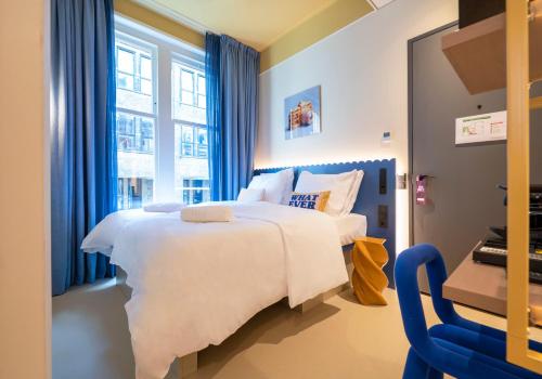 a bedroom with a large white bed and a window at City Hotel Rembrandt Square - Just renovated in Amsterdam